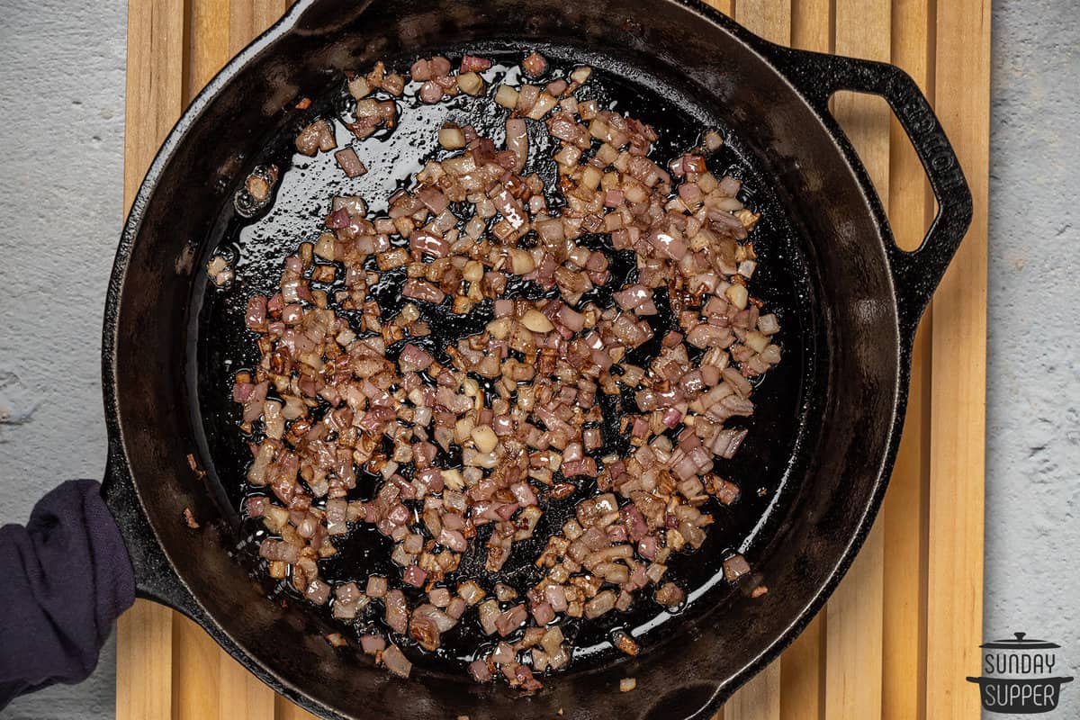 mushrooms and onions cooking in a pan