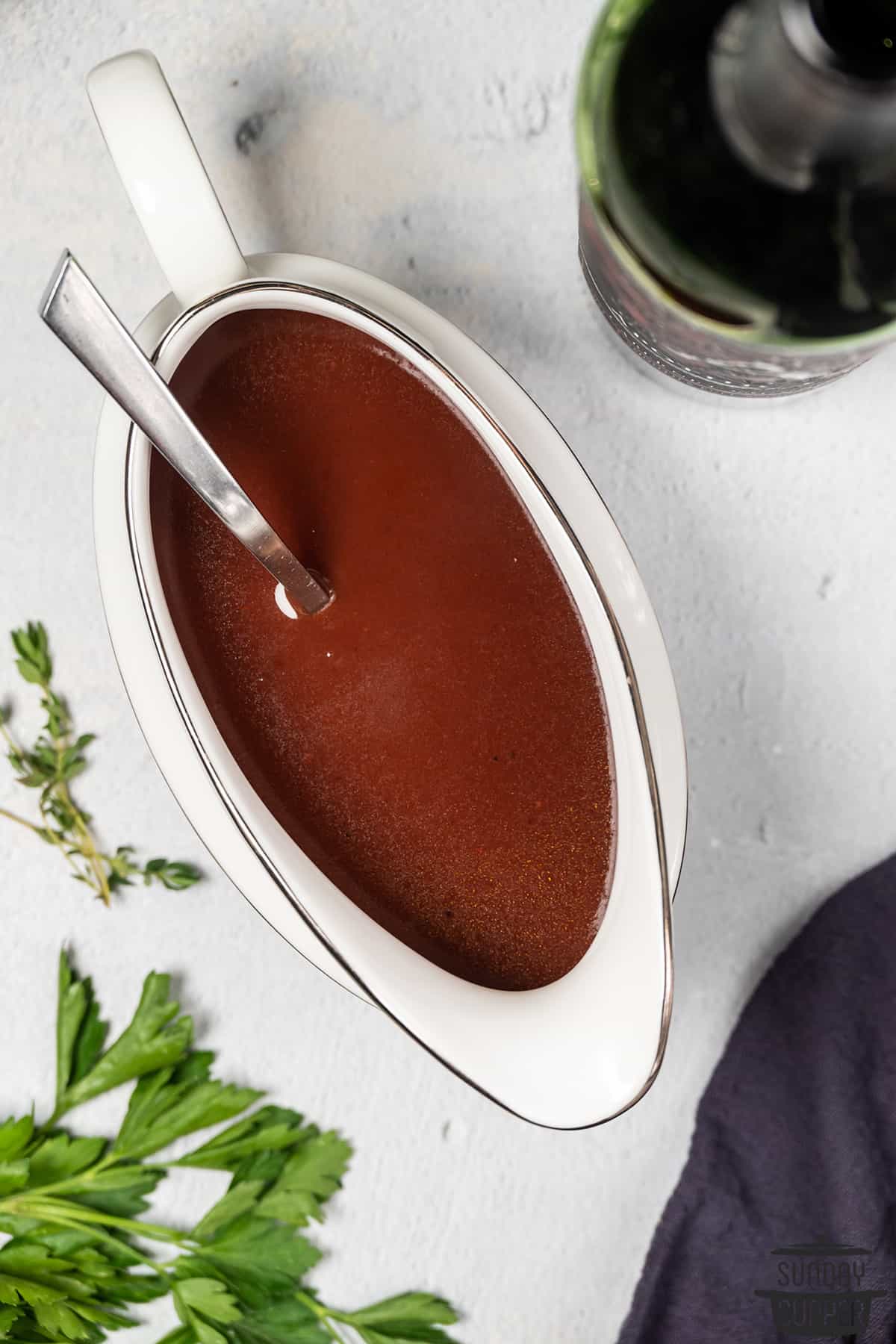 espagnole sauce in a gravy boat with a spoon