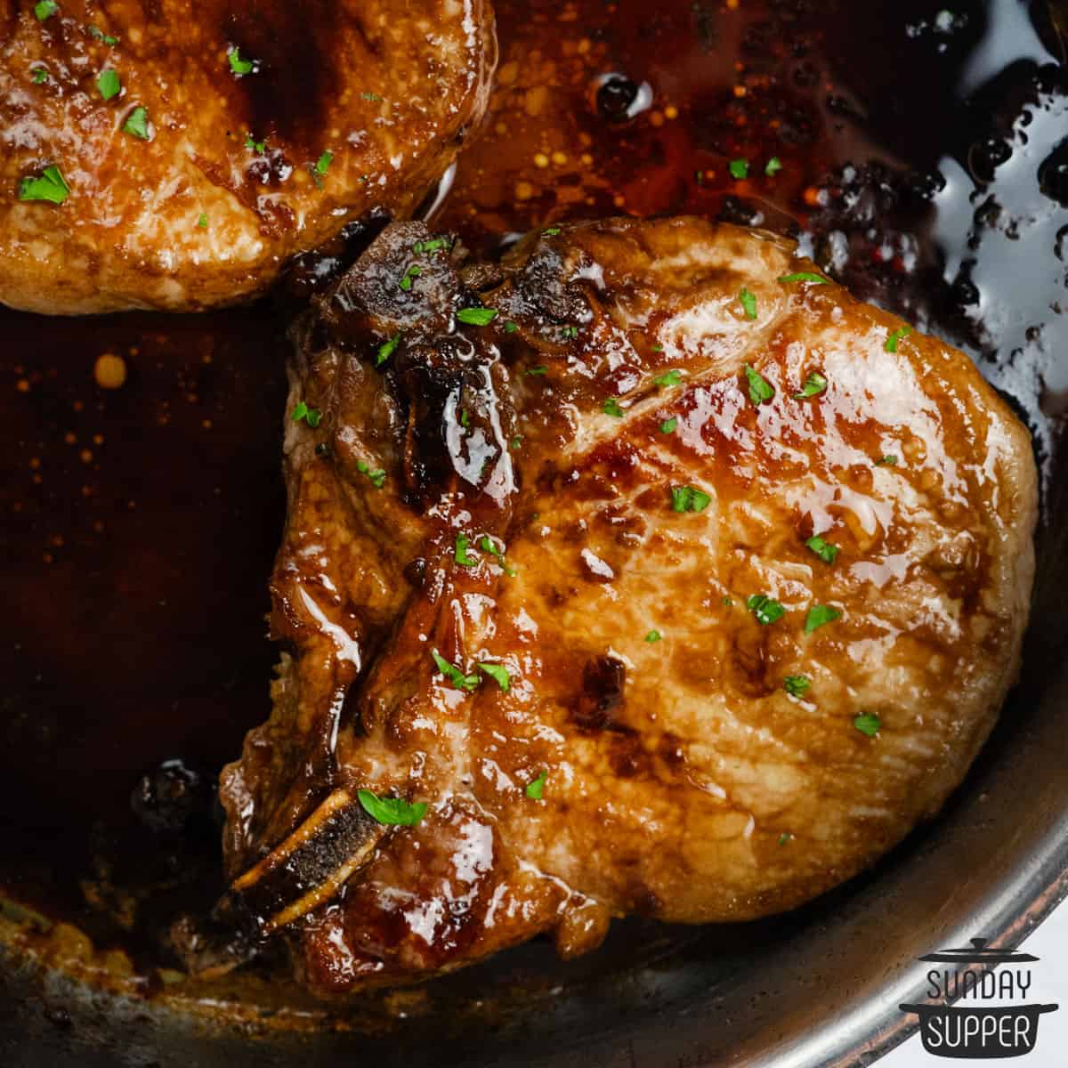 closeup of honey glazed pork chops in the skillet