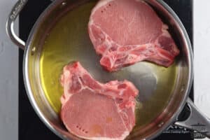 pork chops added to skillet in oil