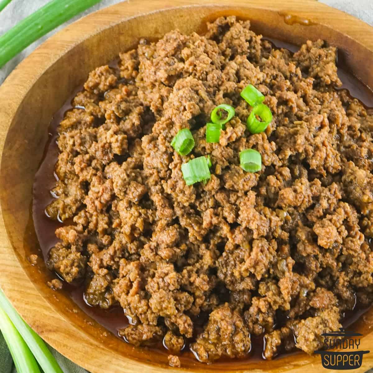 cooked taco meat in a bowl with green onions