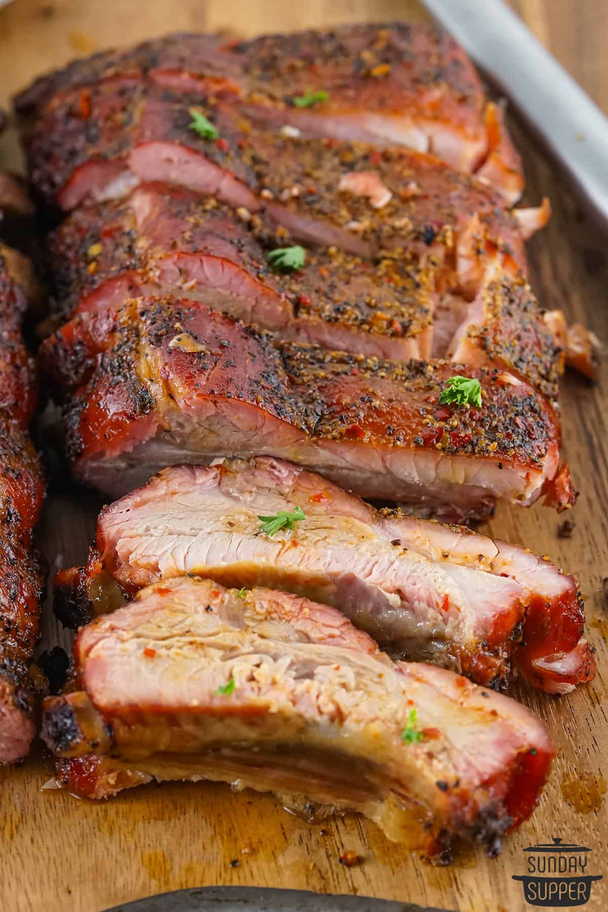 sliced smoked pork ribs on a serving board