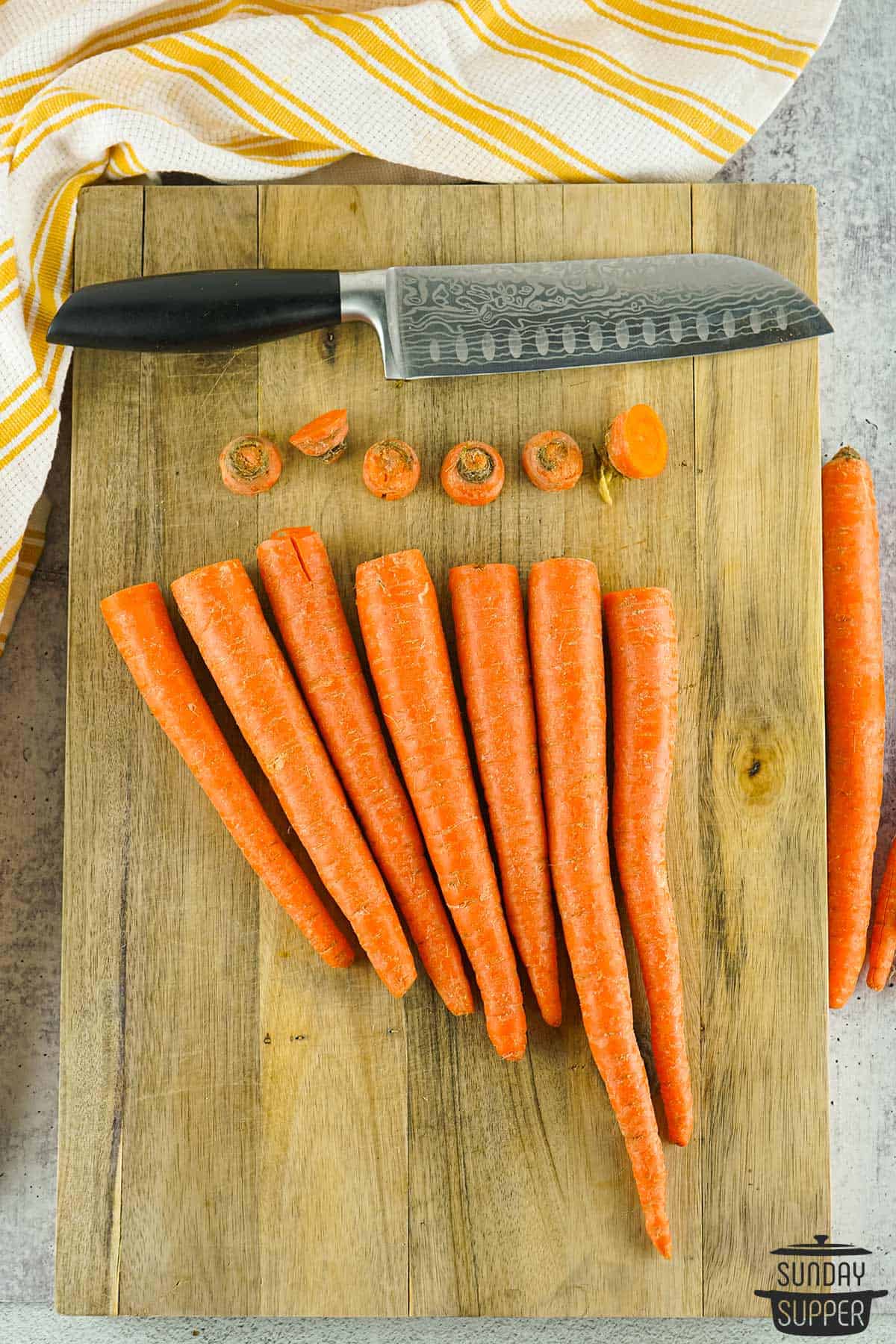 the tops cut off carrots on a cutting board