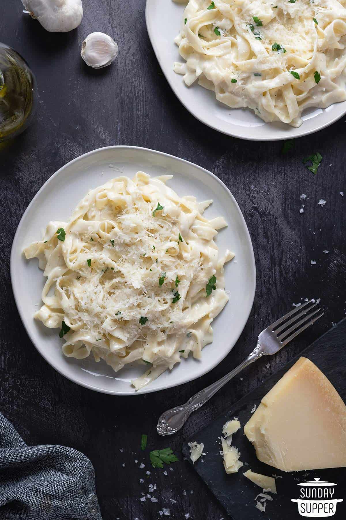 a plate of fettuccine alfredo with extra parmesan and garlic
