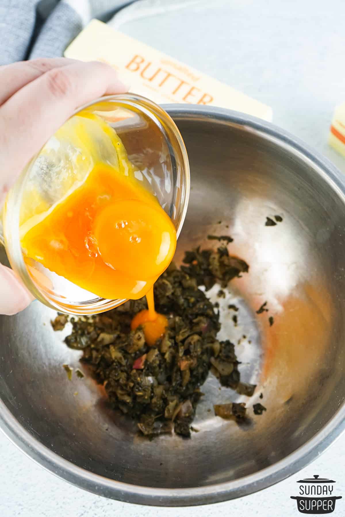 adding egg yolks to bearnaise reduction in metal pot