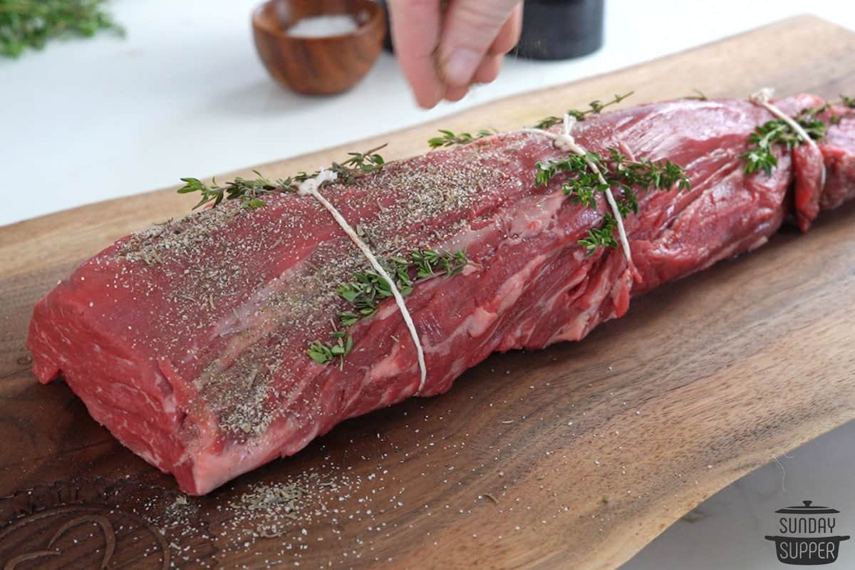 seasoning beef tenderloin on a cutting board