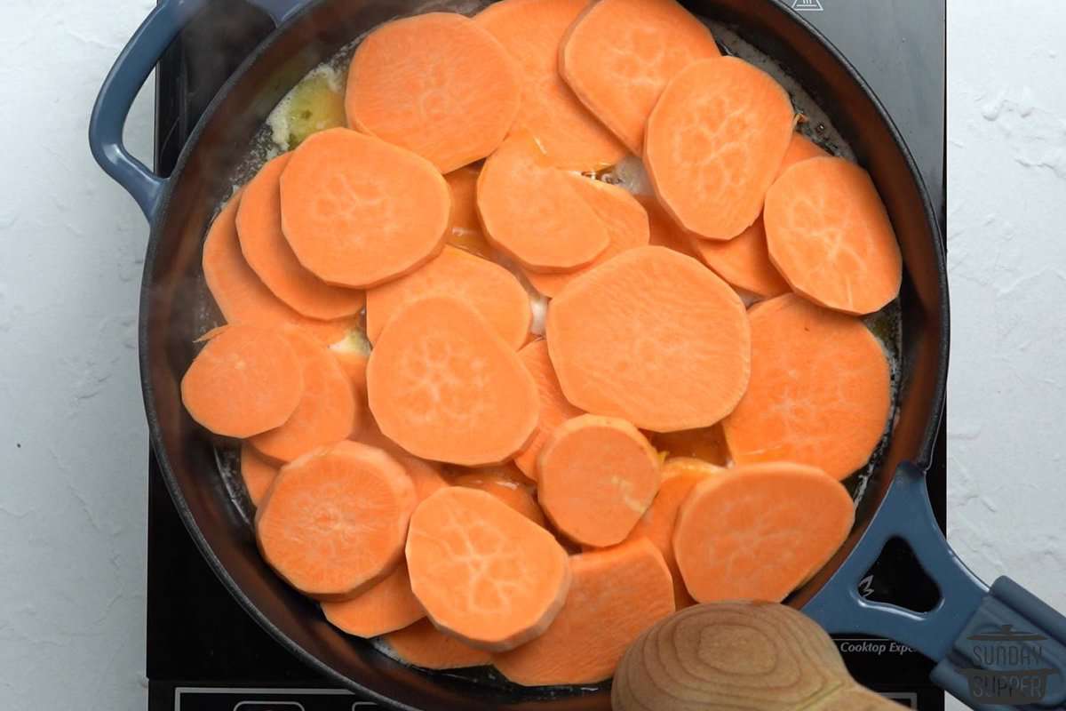 adding sliced sweet potatoes to the skillet