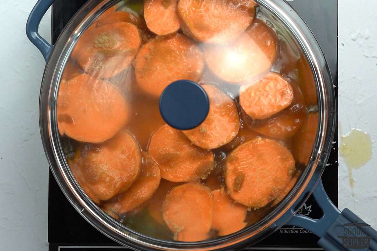 simmering candied yams in a skillet