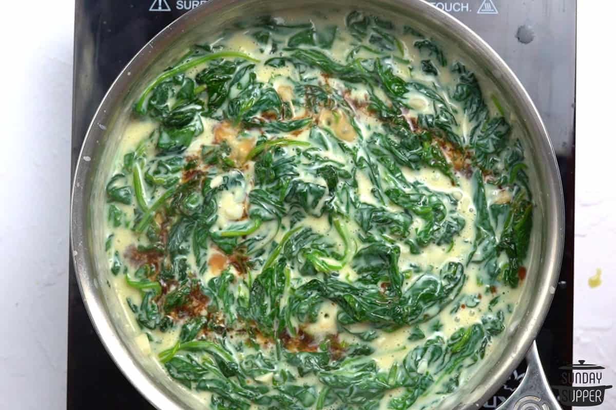 adding balsamic vinegar to creamed spinach in a pot