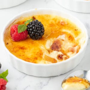a cracked into cup of creme brulee with berries