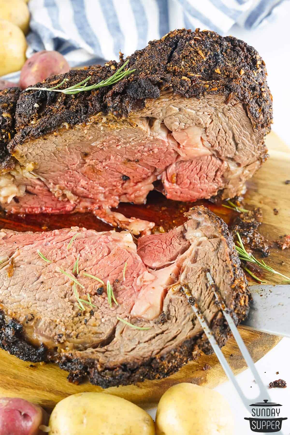 1 slice of grilled prime rib laying on a wood cutting board