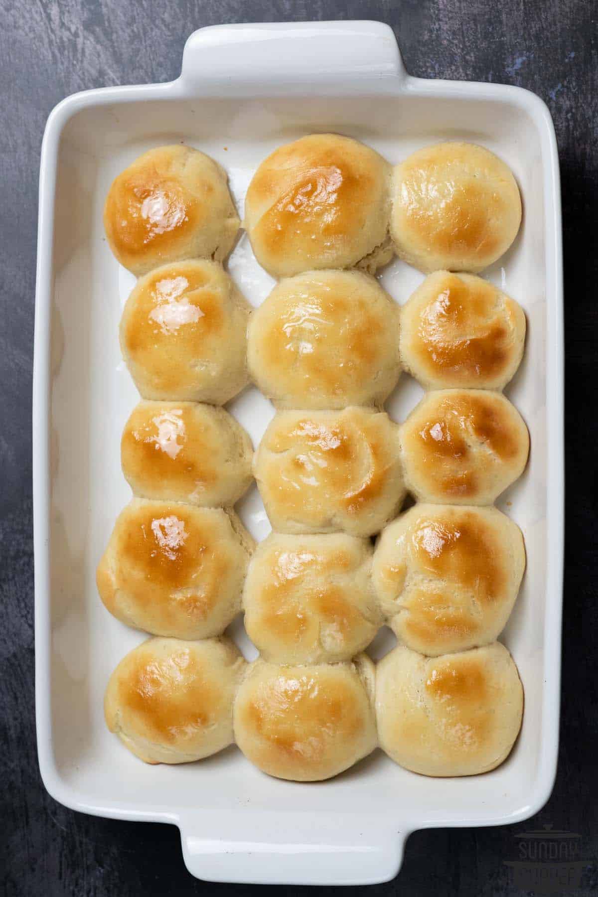 15 quick dinner rolls in a white baking dish with golden-brown tops
