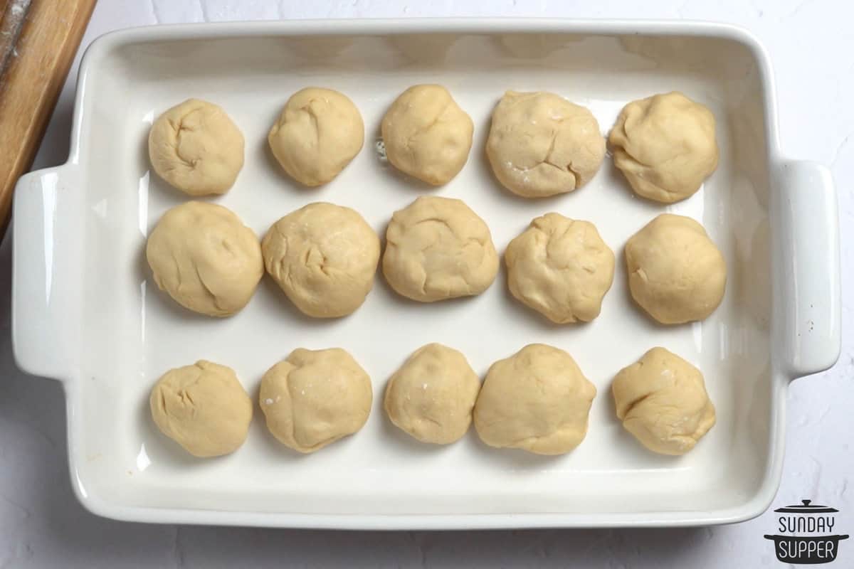 dough balls for dinner rolls in a baking dish