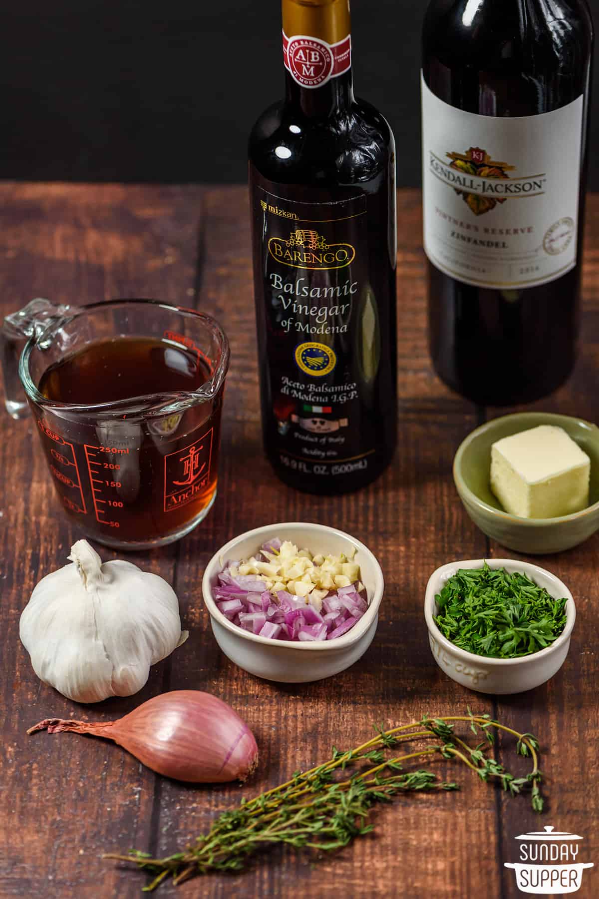 ingredients for red wine reduction on a wooden board