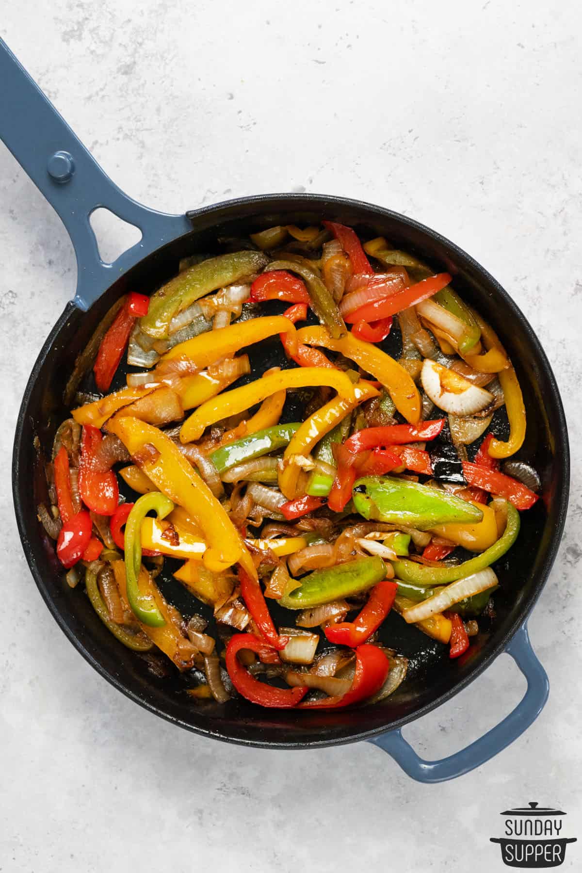 overhead photo of a skillet with peppers and onions