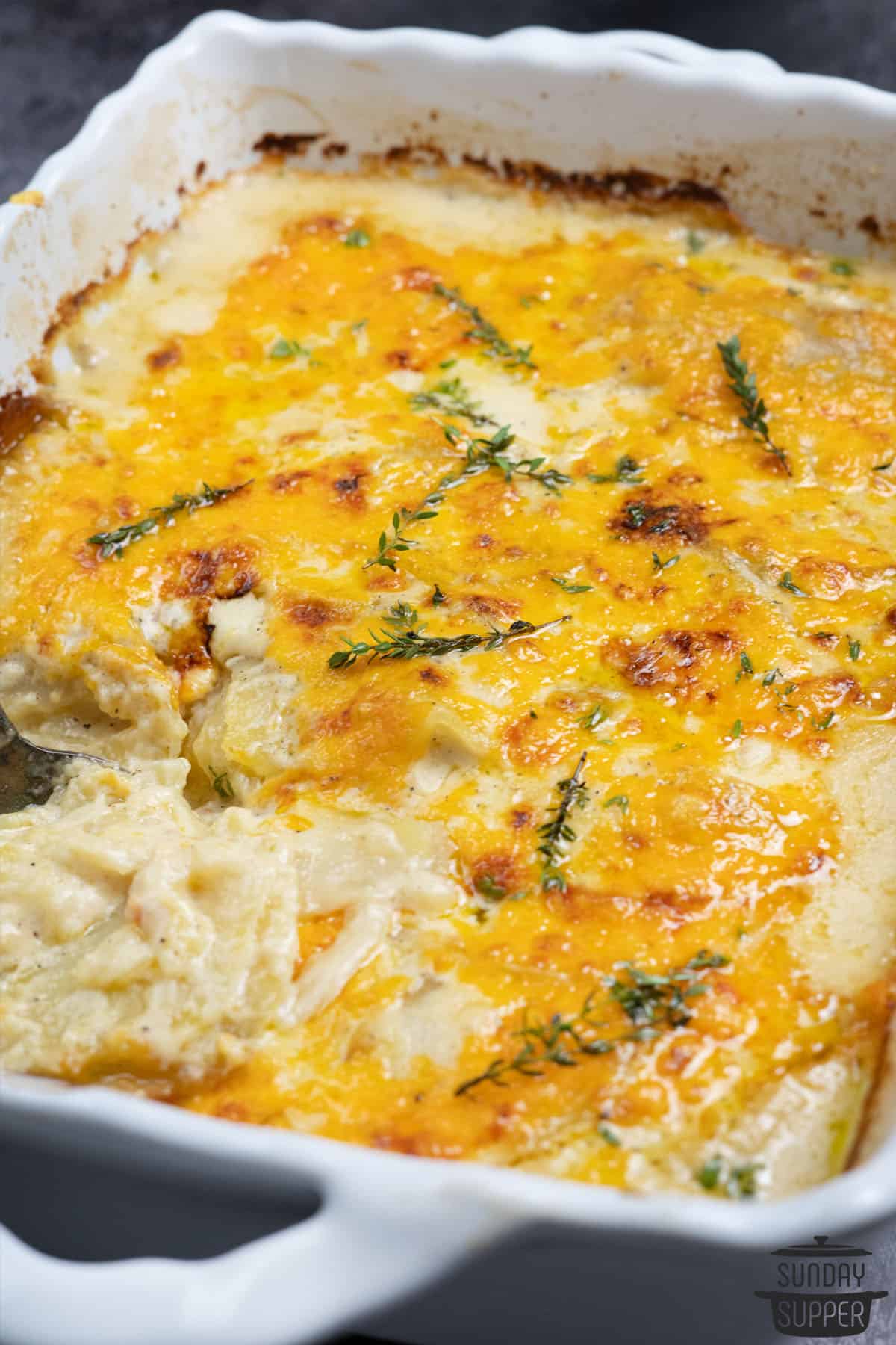 close up of scalloped potatoes in a white baking dish