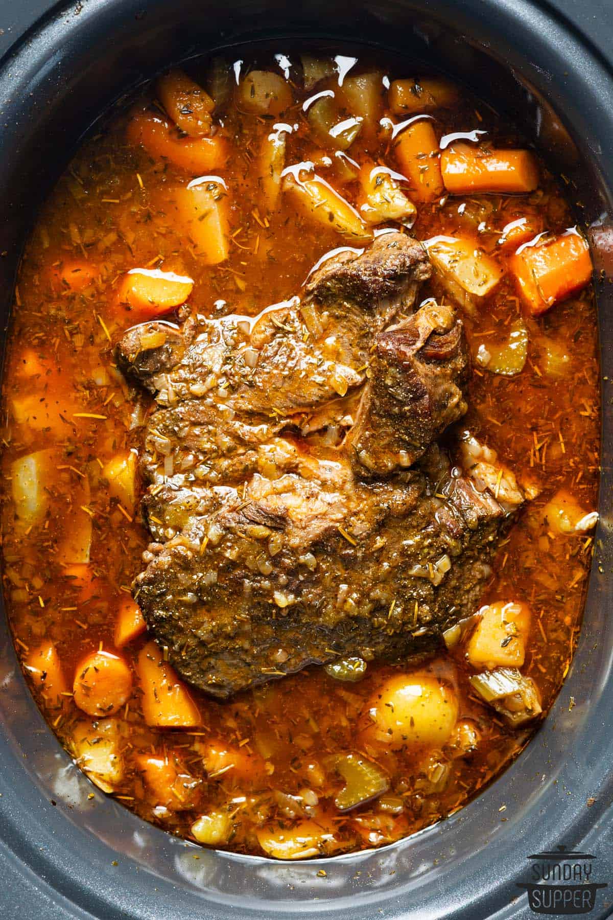 slow cooker chuck roast in the crockpot with potatoes and carrots