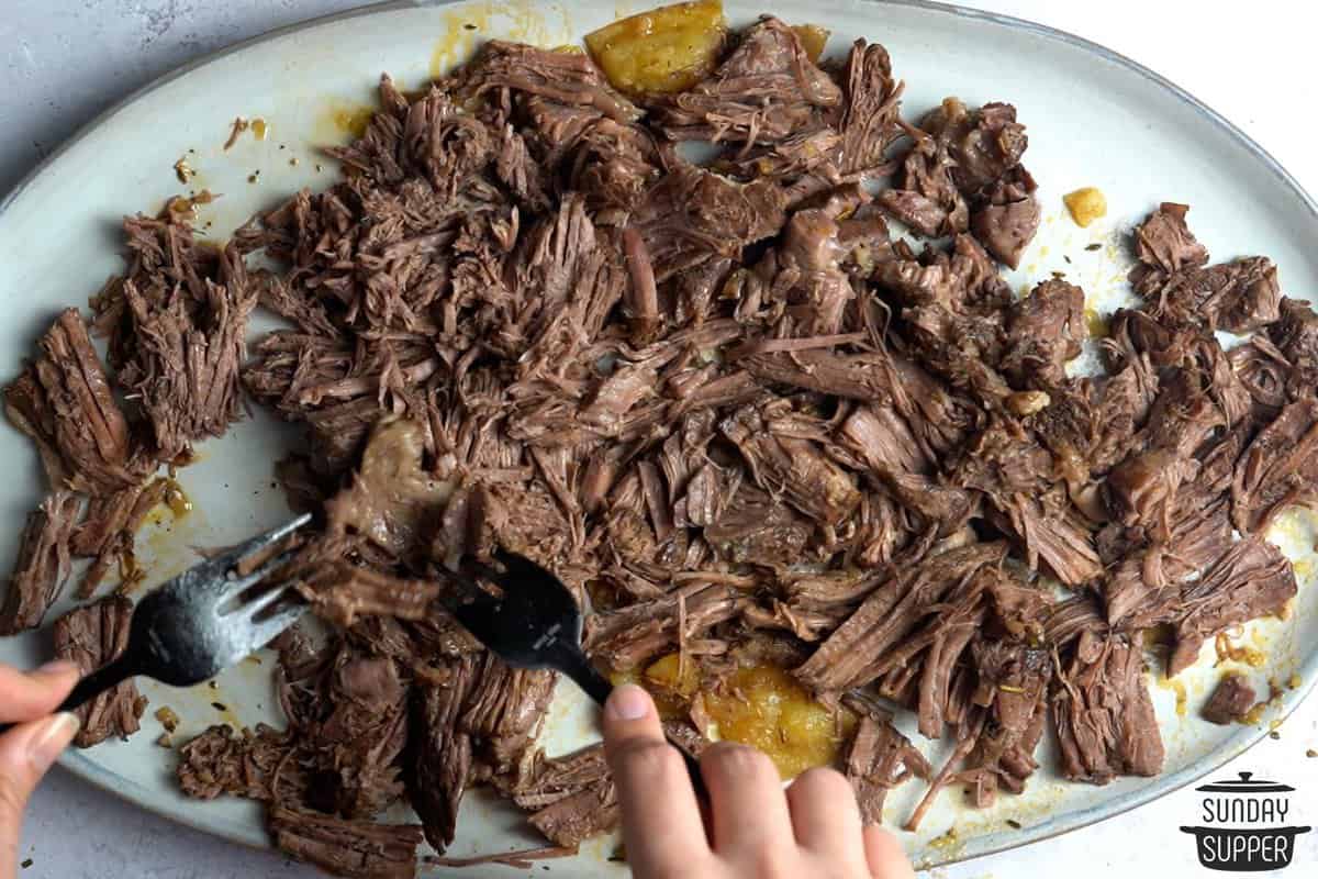 shredding roast beef with two forks