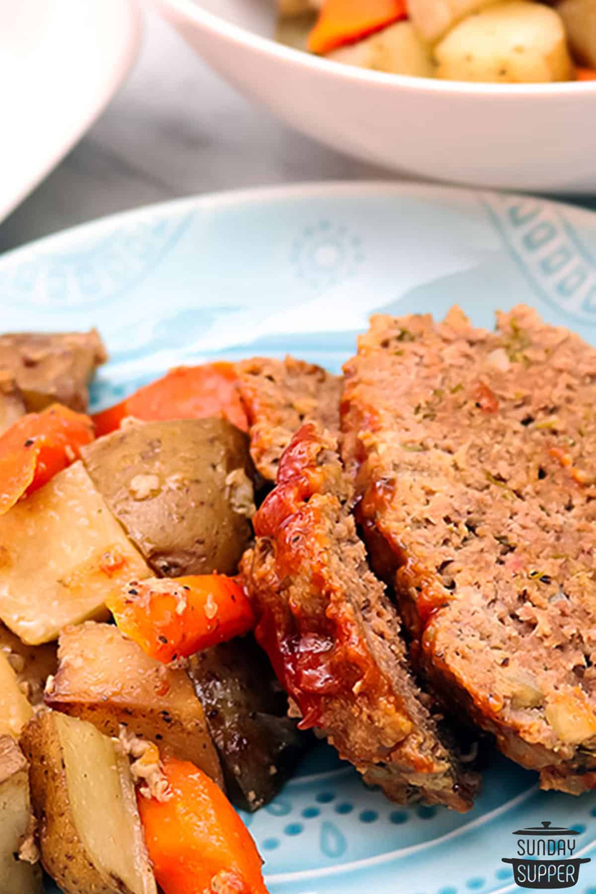 a plate with sliced meatloaf and cooked vegetables