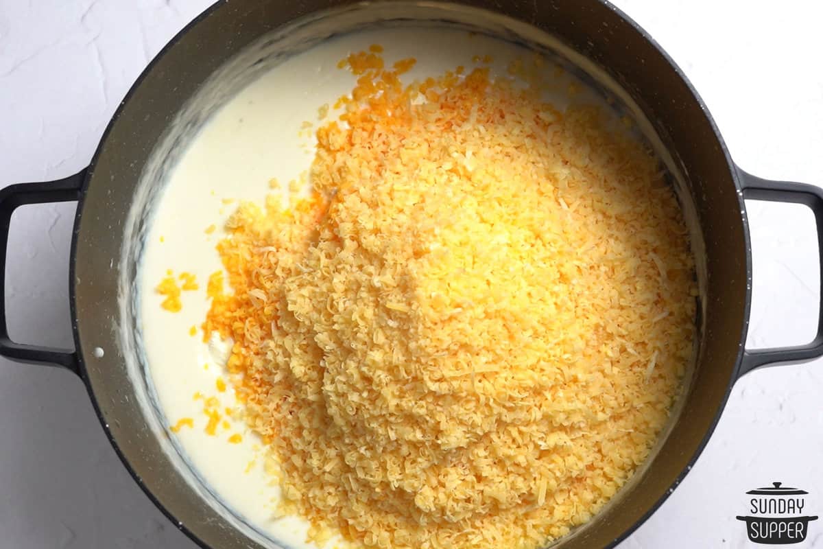 adding shredded cheese to a pan