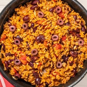 spanish rice and beans with olives in a pan
