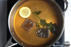 tea steeping in a pot with lemon and herbs