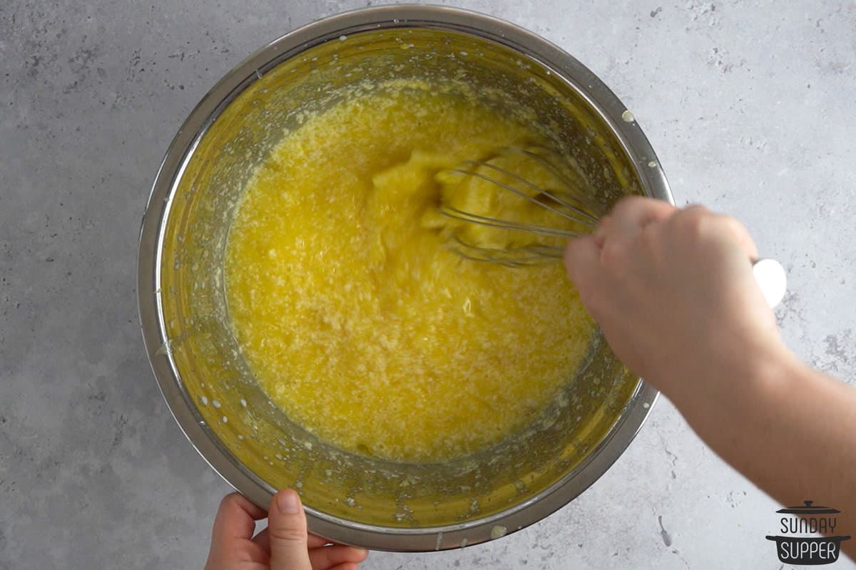 the pineapple, eggs and sugar being mixed in a bowl