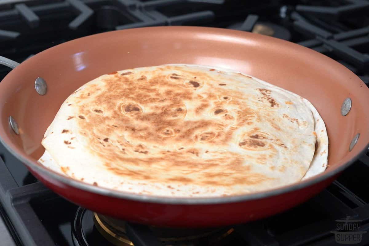 the assembled quesadilla crisped and cooked in a pan