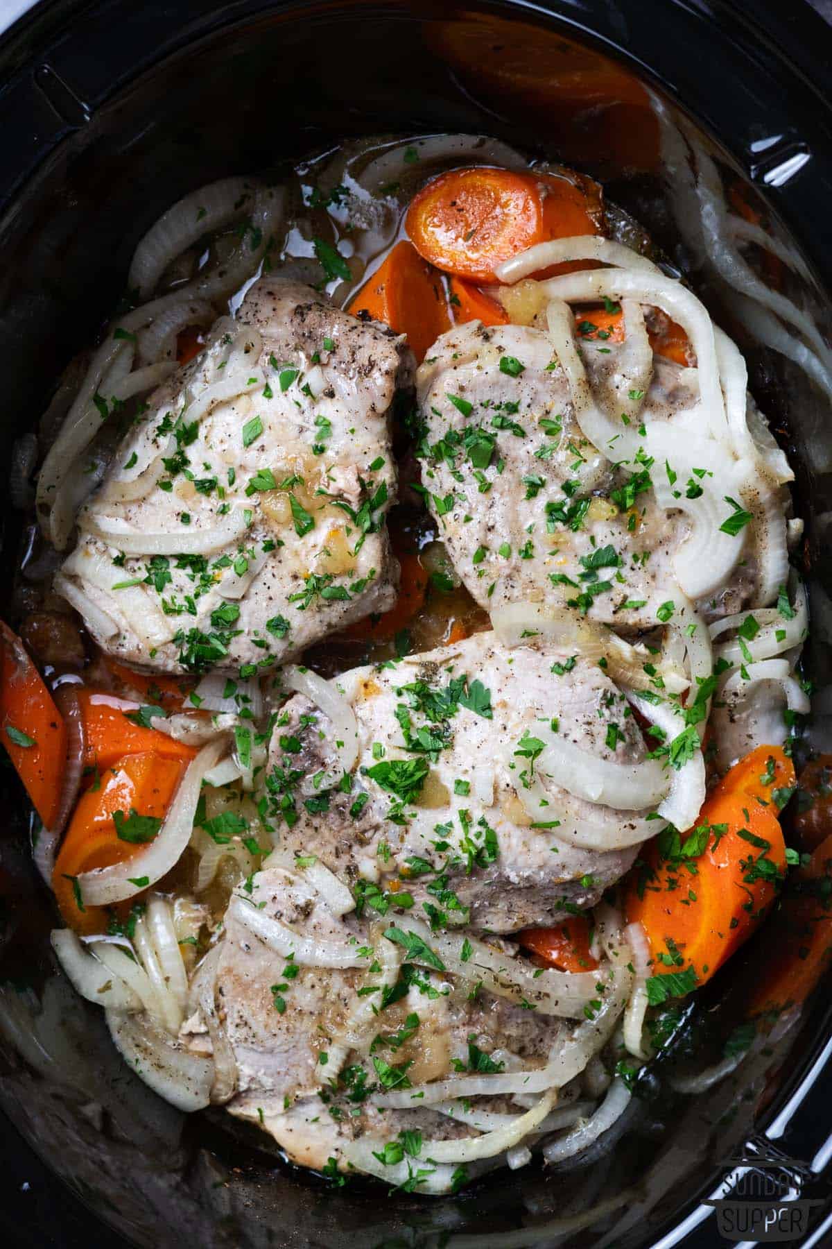 pork chops, carrots, onions and potatoes in a crock pot