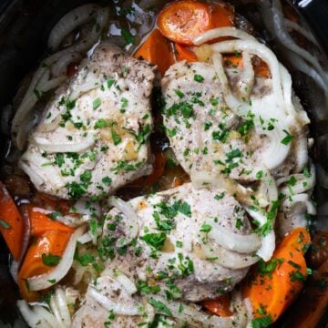 a crock pot filled with pork and vegetables
