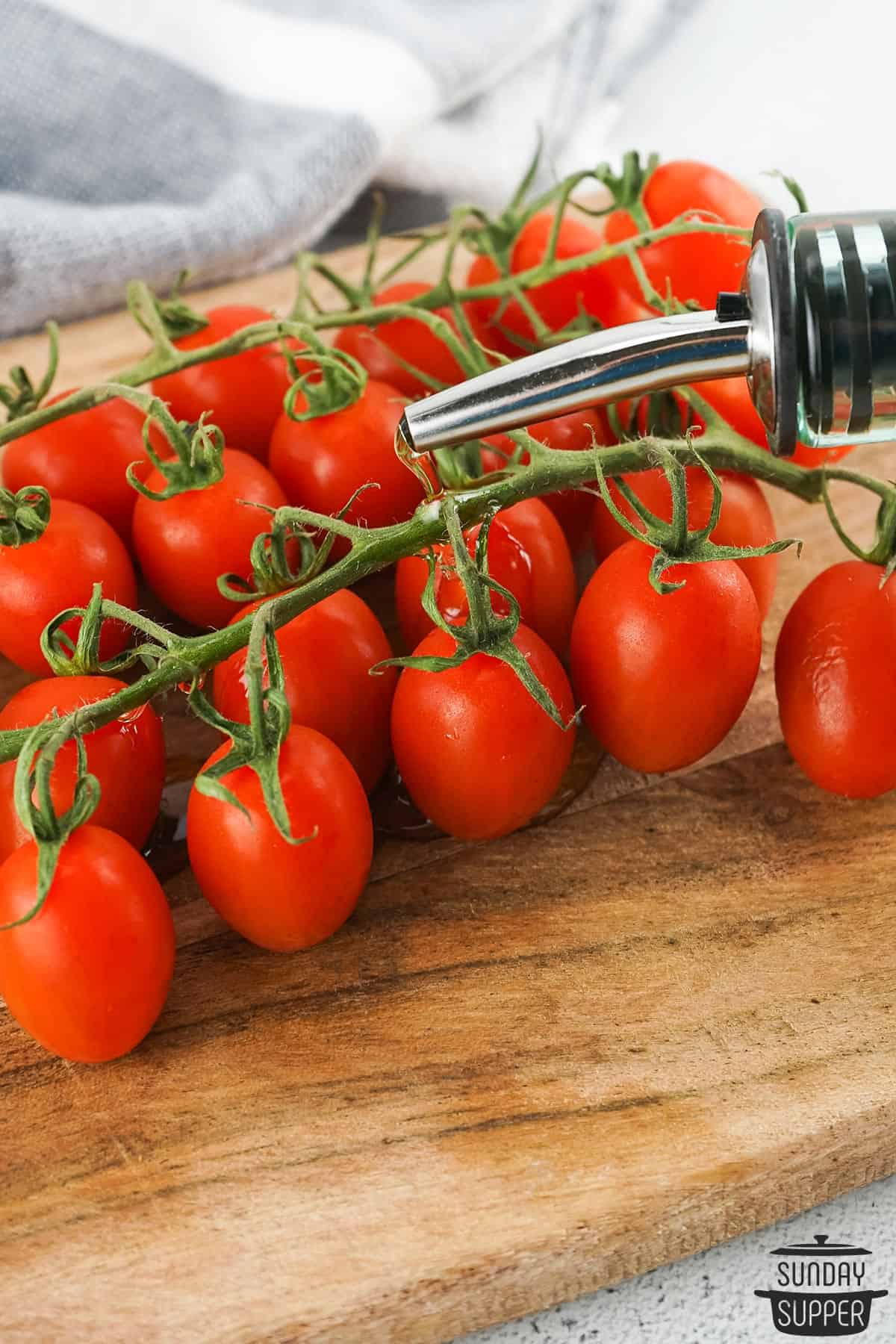 oil being poured on the vine tomatoes