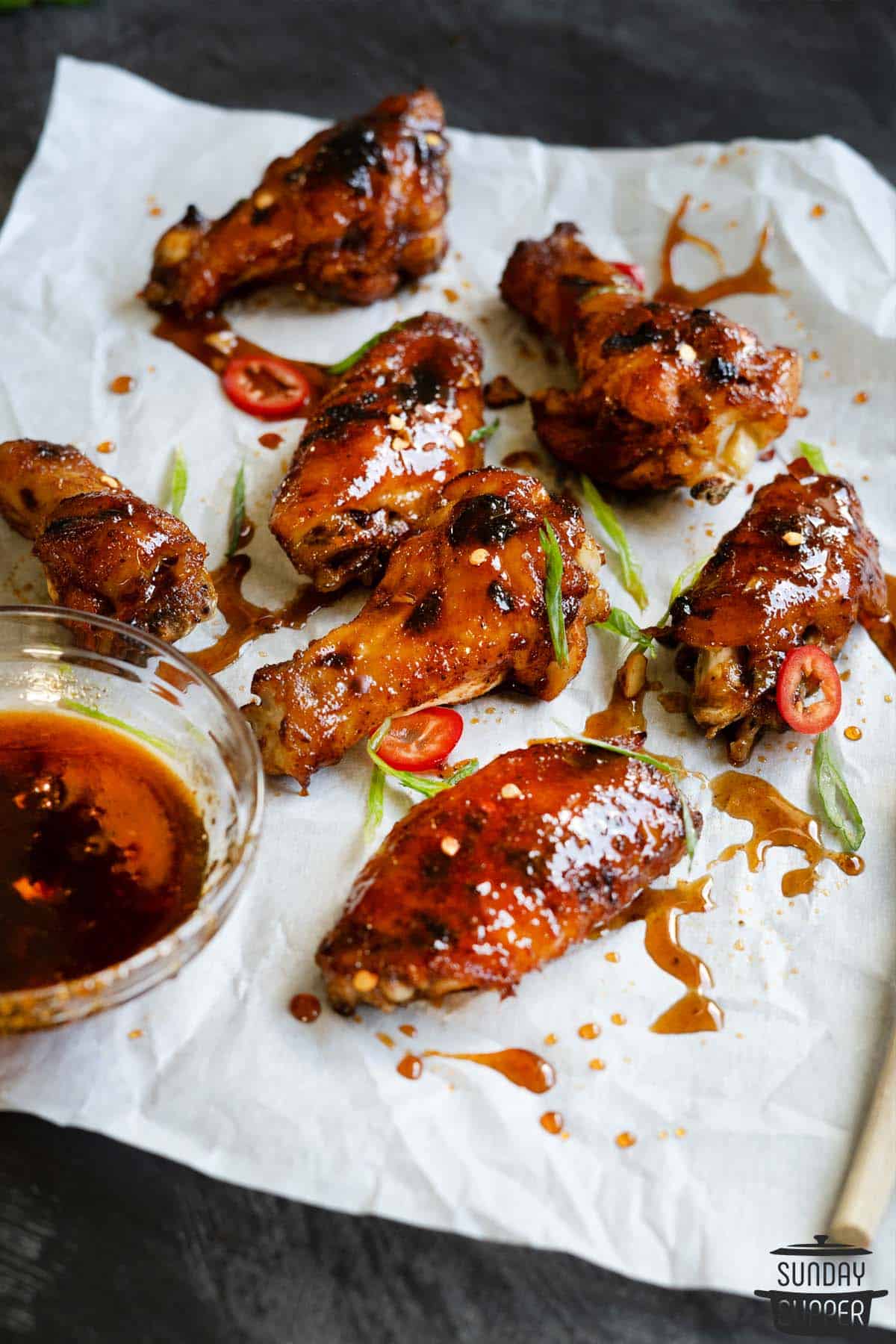 Instant pot chicken wings on parchment paper with honey sriracha sauce
