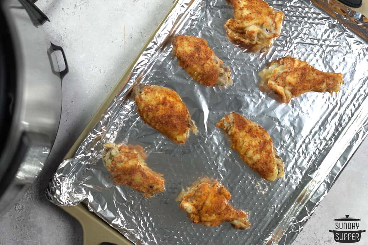 Instant pot chicken wings on baking sheet lined with aluminum foil
