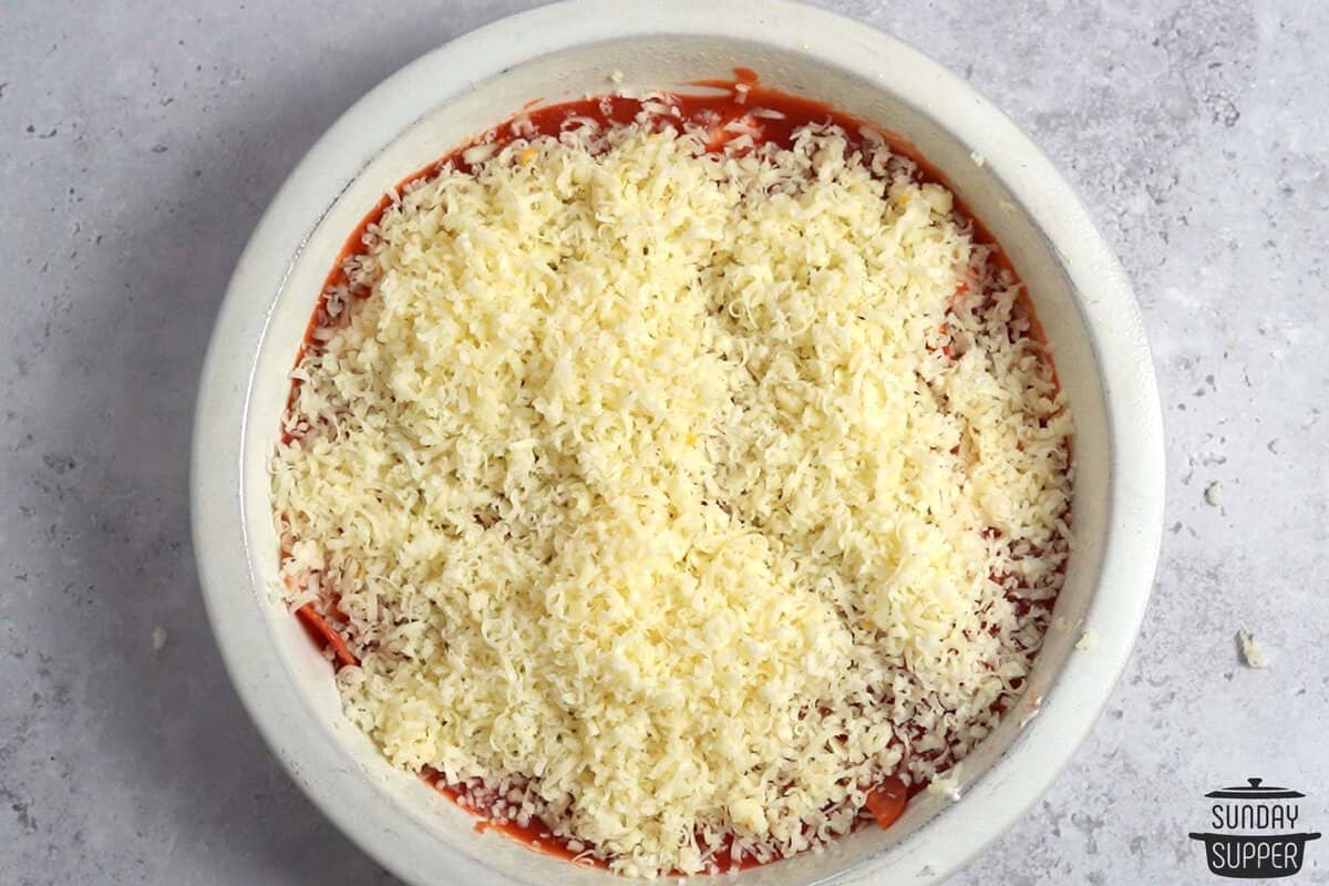 topping with shredded mozzarella cheese