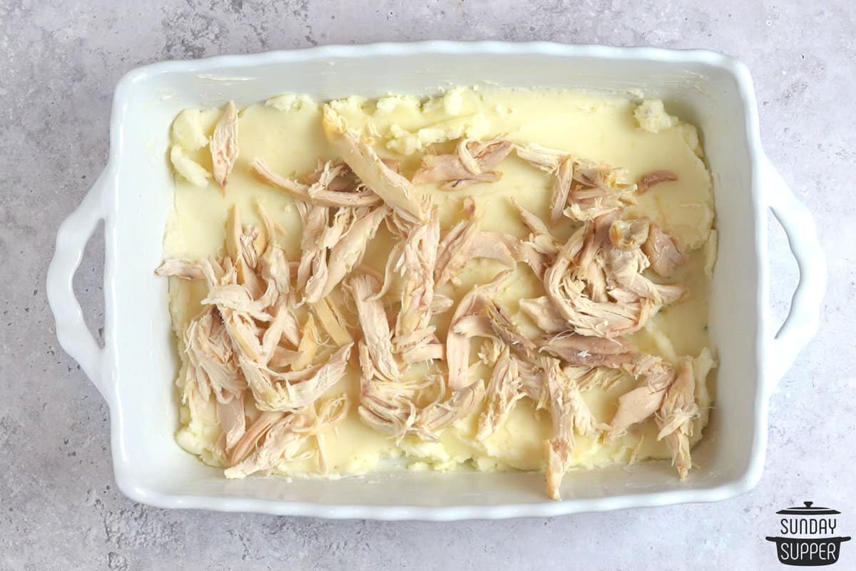 layering mashed potatoes and shredded turkey in a casserole dish