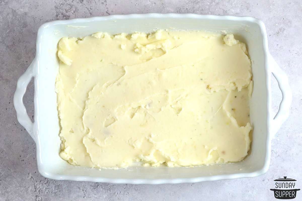 spreading mashed potatoes in casserole dish