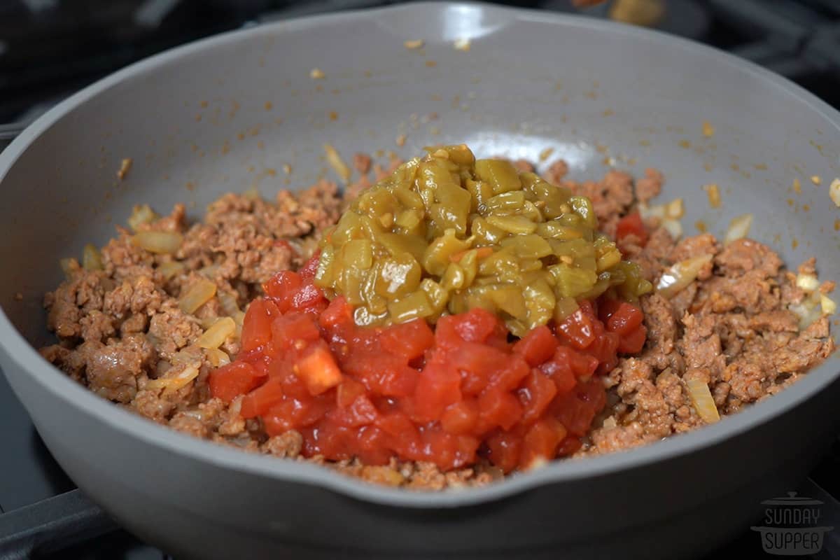 a can of tomato and a can of chiles added to the pot of chorizo