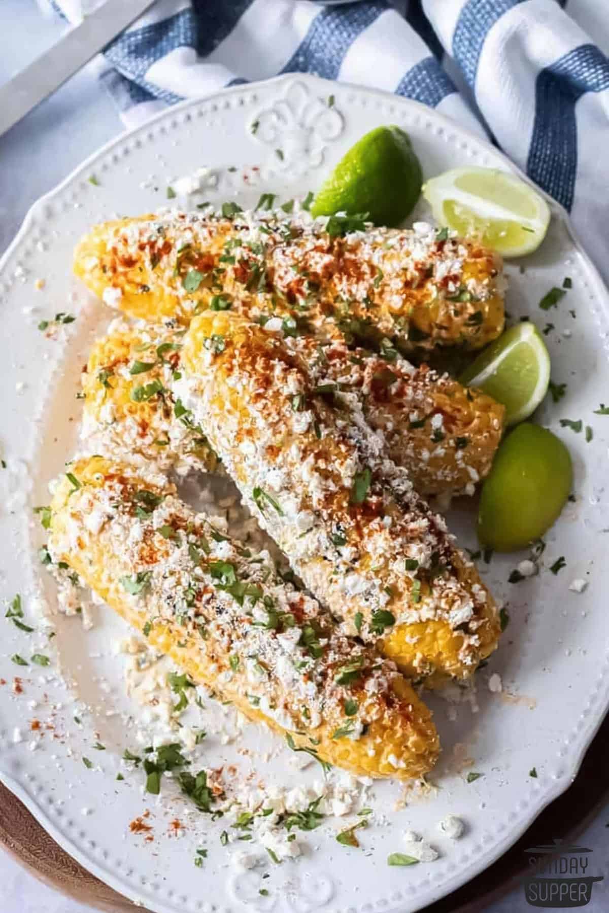 cheese and cilantro sprinkled on the corn and ready to serve with limes