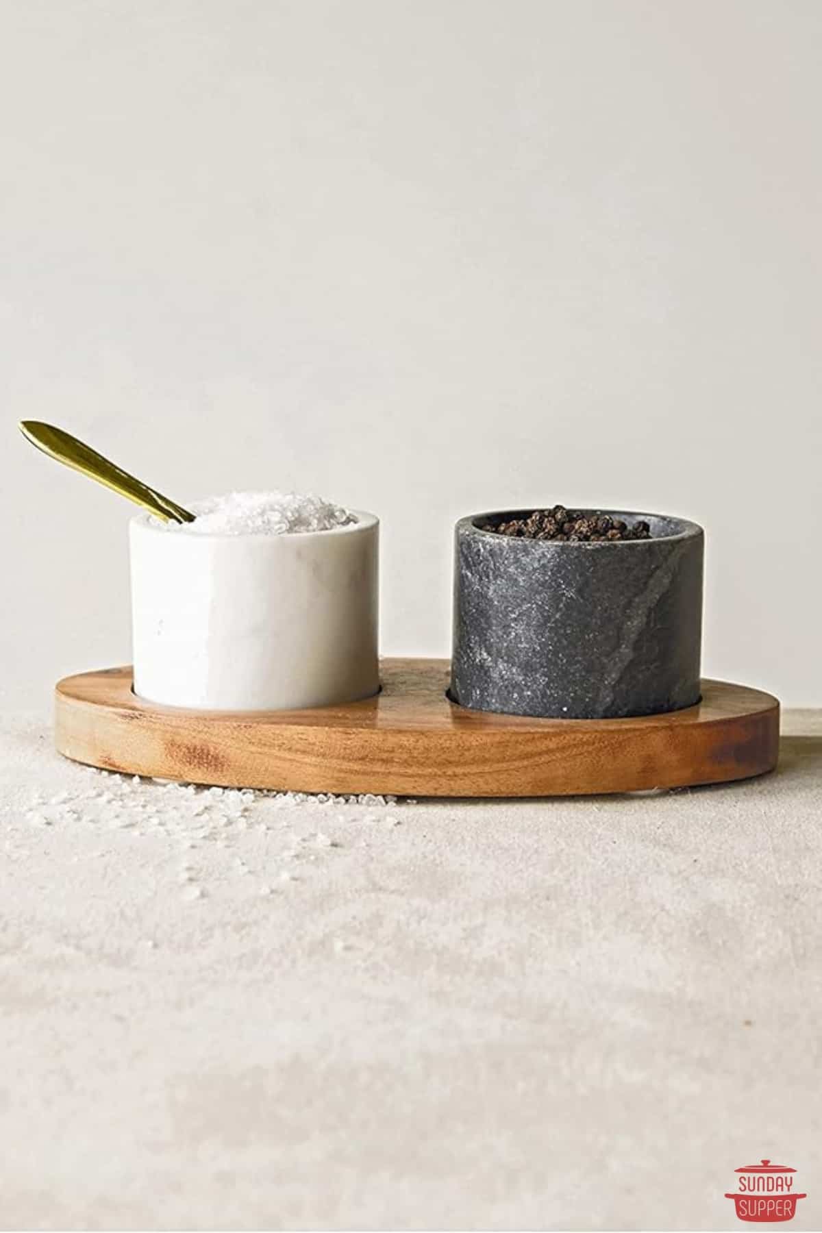 marble salt and pepper bowls on a wooden board