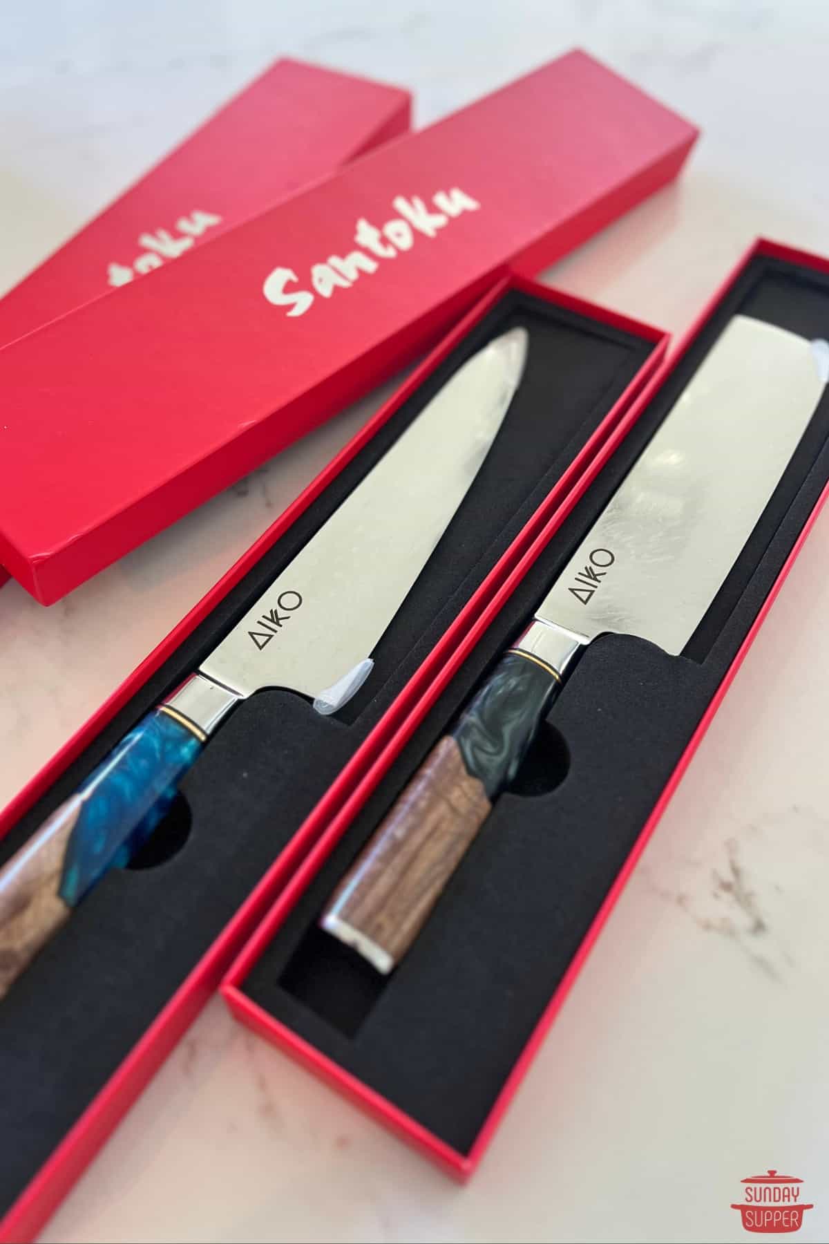 a pair of santoku knives in boxes