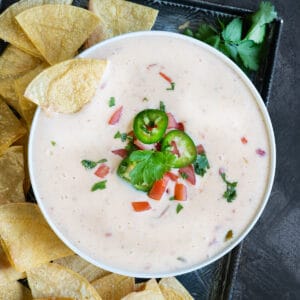 a chip dipped in a bowl of queso blanco