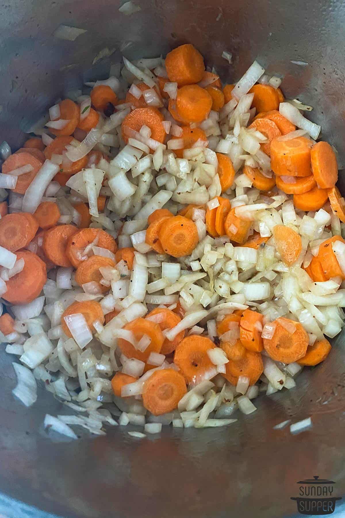 the onions and carrots added to the pot to saute