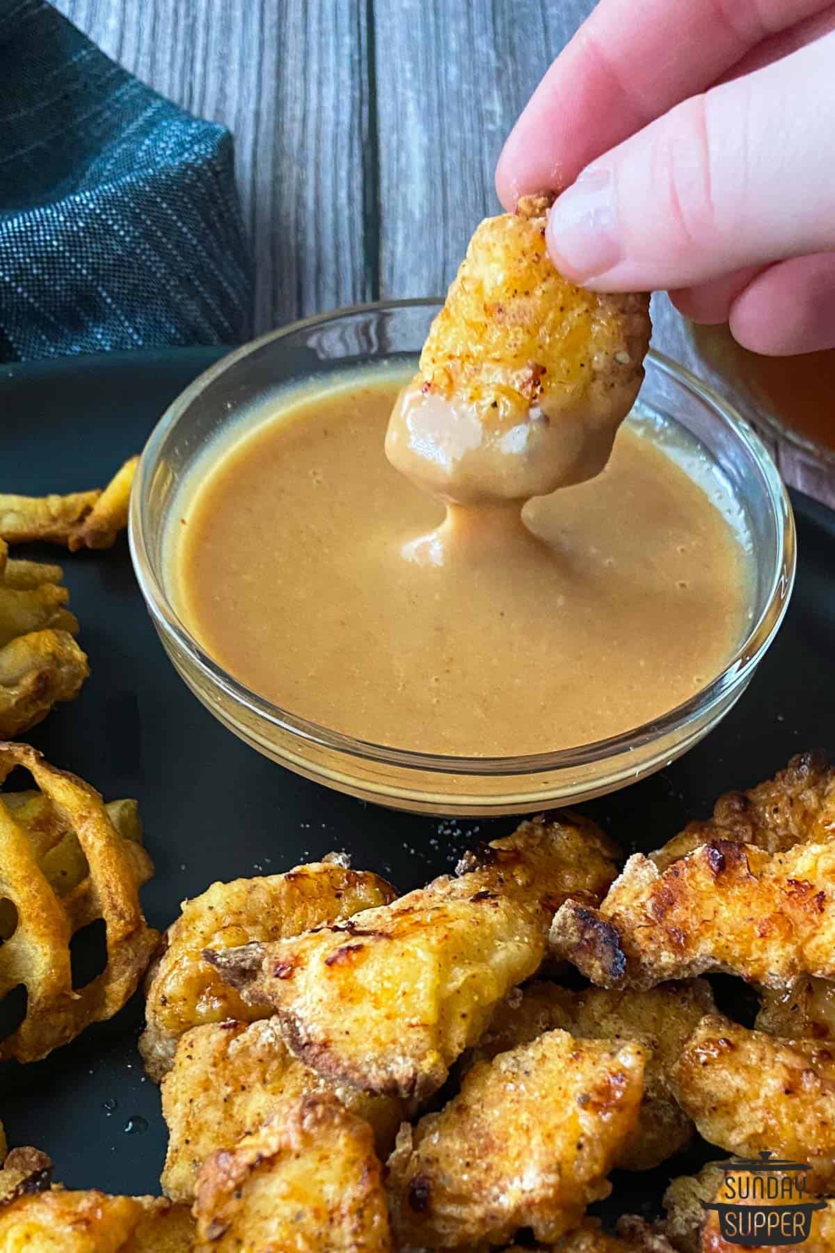 a bowl of chick fil a sauce with a nugget dipped into it