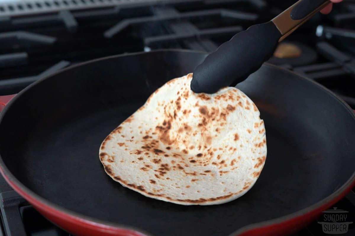 warming a tortilla on the stove top