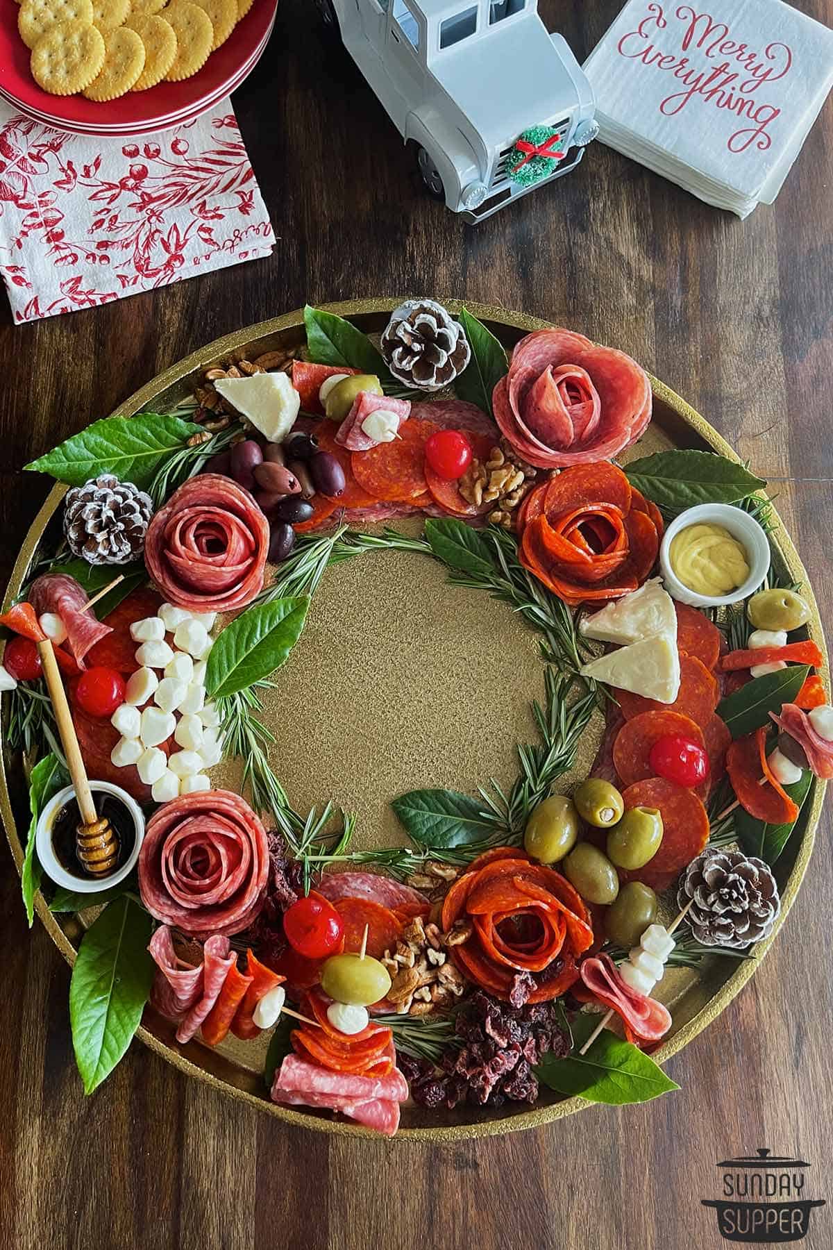 a charcuterie board shaped like a wreathe with cheese and meat flowers