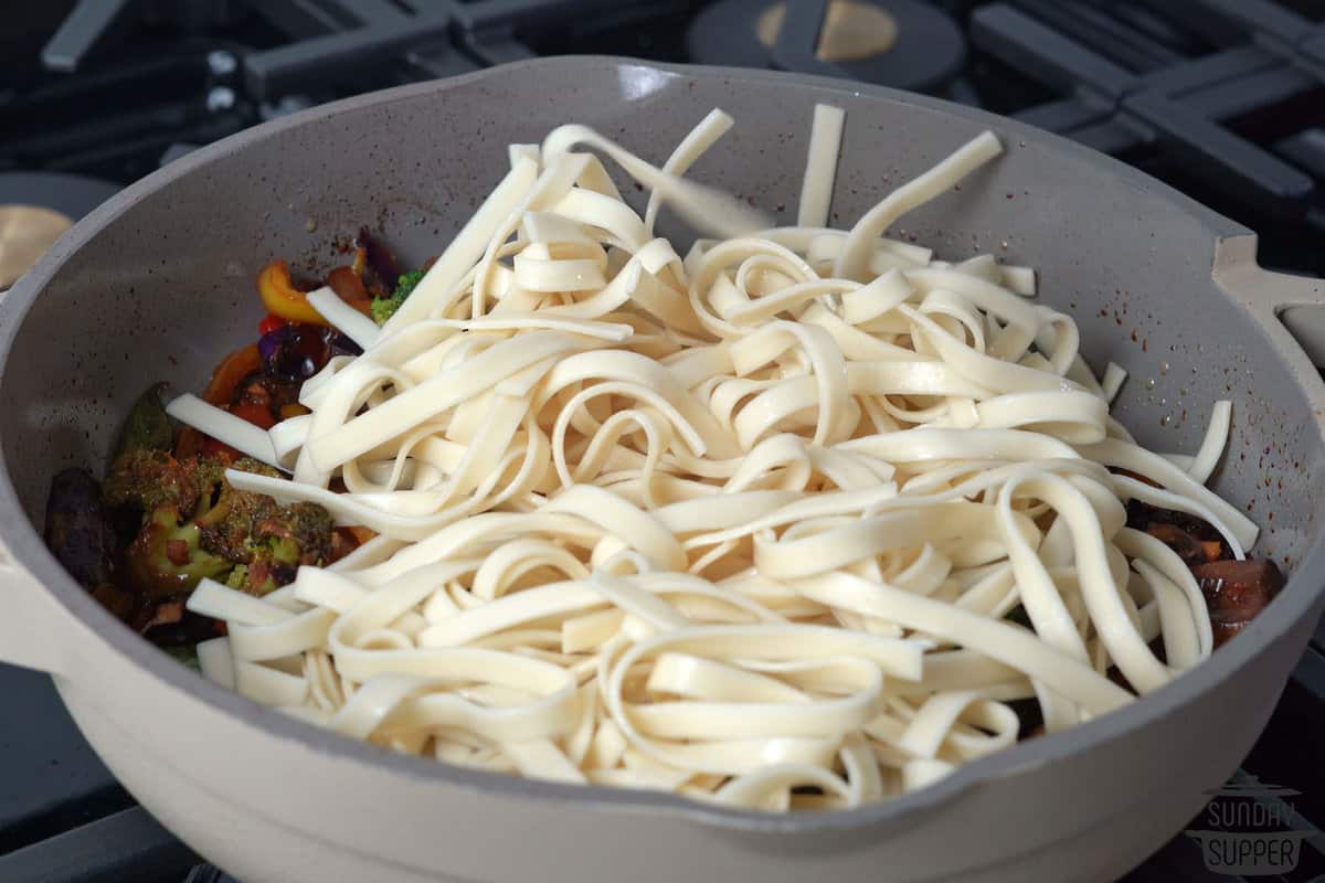 adding noodles to the skillet