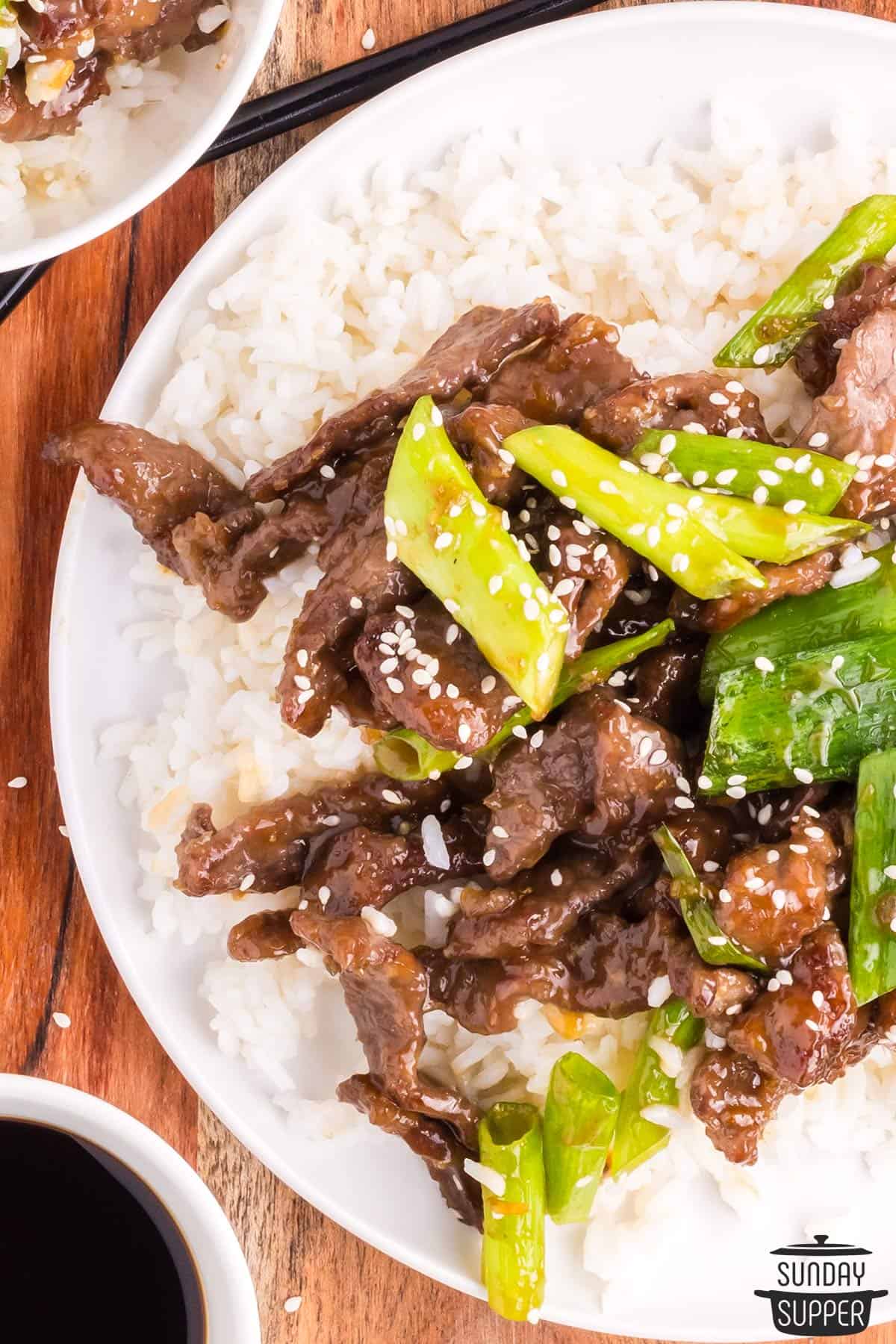 a pile of mongolian beef on white rice on a plate