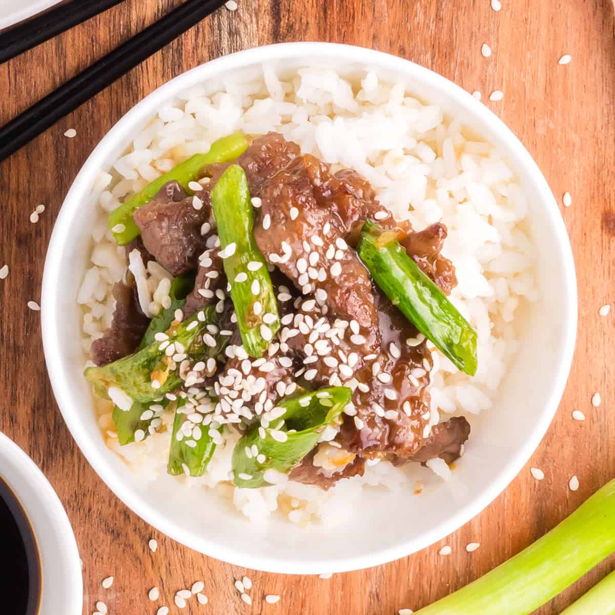 a top down view of a bowl of white rice and mongolian beef