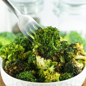 air fryer broccoli on a fork over a bowl