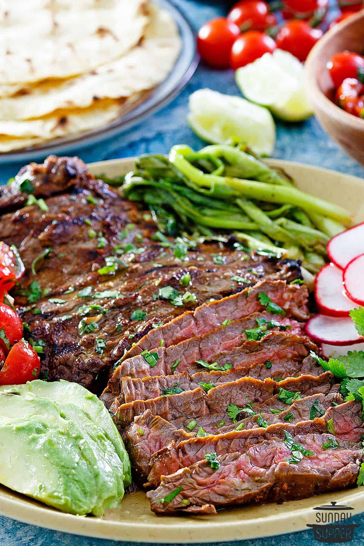 a dinner plate filled with carne asada, avocado, and radish